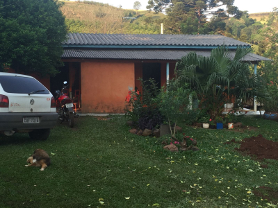 Frente da casa, o carro e a moto da família