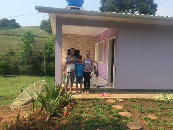 A Família Deonh em frente a casa financiada pelo MCMV Rural