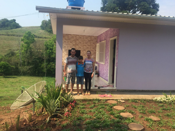 A Família Deonh em frente a casa financiada pelo MCMV Rural